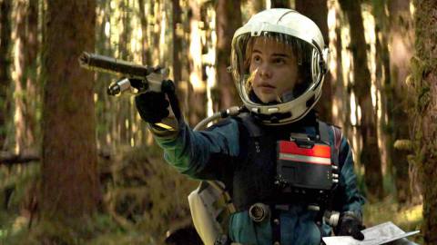 Sophie Thatcher, a young woman in handmade-looking space gear, points a handmade-looking gun offscreen in Prospect
