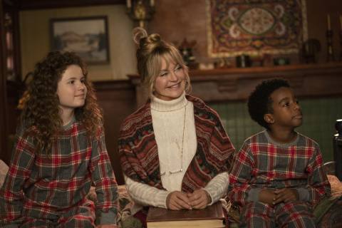 Goldie Hawn and the child cast of The Christmas Chronicles 2 sit in stiff poses wearing competing loud patterns