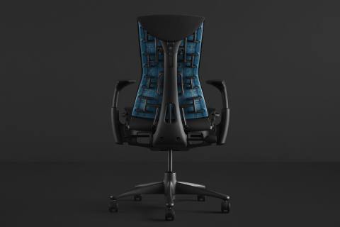 An Embody Gaming Chair, in black, with a bright blue support on the back.
