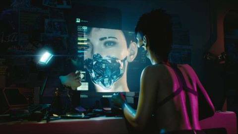 A cybernetic woman looks at herself in a computer monitor in Cyberpunk 2077
