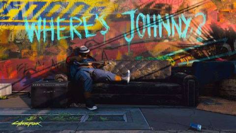 A man plays guitar on a sofa somewhere in Night City below graffiti that asks “Where’s Johnny?” From Cyberpunk 2077, E3 2019.
