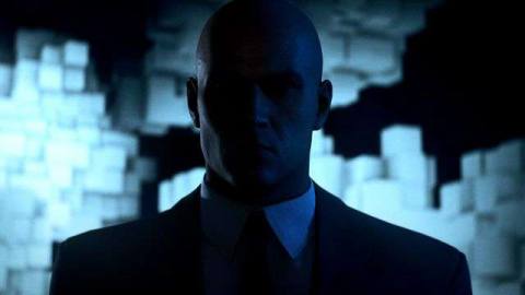 a close-up of Agent 47, with glowing blocks behind him, in Dubai in Hitman 3