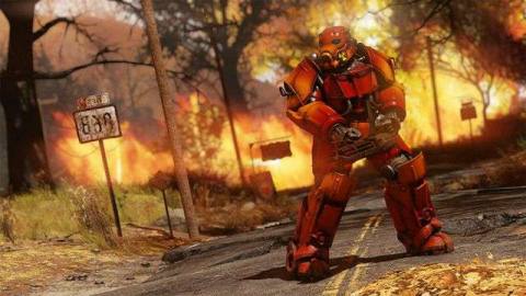 Fallout 76 - a power armor wearing soldier with a mini gun poses menacingly. His armor is painted red, and a forest fire rages in the background.