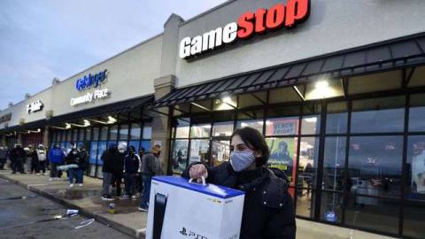 A man wearing a face mask leaves GameStop with the new PlayStation 5