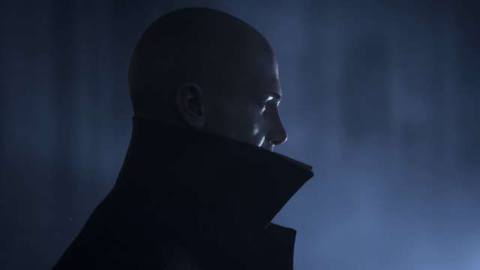 Hitman 3 - Agent 47 in profile, wearing a high collared coat. He’s backed by an ominous looking blue light.