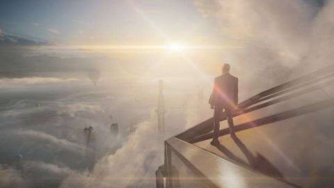 Agent 47 standing on top of a glass skyscraper in Hitman 3