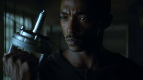 Anthony Mackie as an android in Outside the Wire examines a silver tool