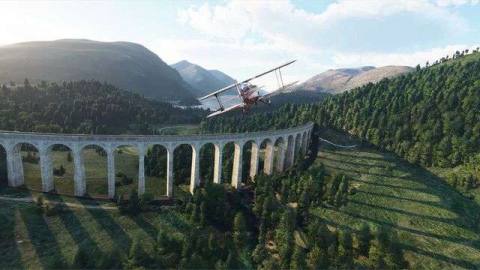 A red biplane flied over a rustic train trestle bridge in rural Britain.