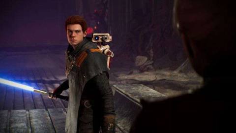a young brown-haired man, Cal Kestis, holds a blue lightsaber in a screenshot from Star Wars Jedi: Fallen Order