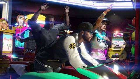a black man playing an arcade racing game while two friends look on in Grand Theft Auto Online’s Diamond Casino Heist update