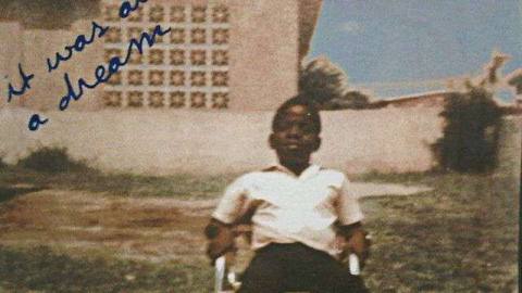 A photo of a young Christopher Wallace sitting outside in a chair.