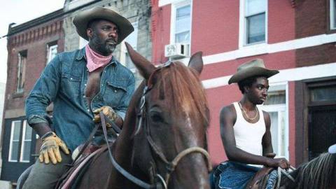 Idris Elba as Harp and Caleb McLaughlin as Cole riding horses in Concrete Cowboy