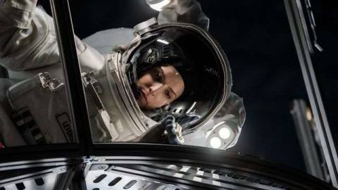 Anna Kendrick, in a space suit, hovers sideways over a grate in Stowaway