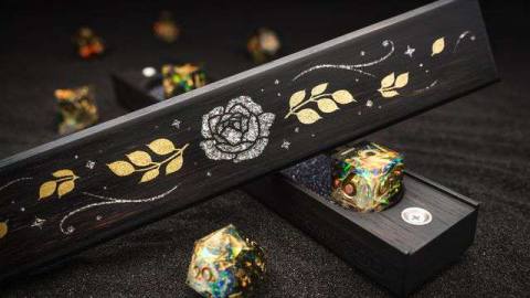An elegant inlaid flower and leaf pattern, rendered in flecks of silver and gold, sit above two creamy, sharp-edged dice to match.