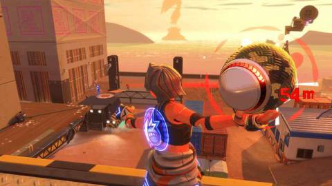 Seen from behind, a player winds up a dodgeball shot, aiming for an opponent across a rooftop in the distance in Knockout City