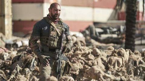 Dave Bautista stands in a field of dead, desiccated bodies in Army of the Dead