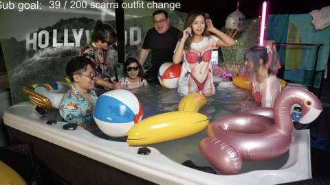 a group of streamers, including Pokimane are hanging out in a hot tub. Pokimane is wearing a shirt dress with a bikini bod printed onto it 