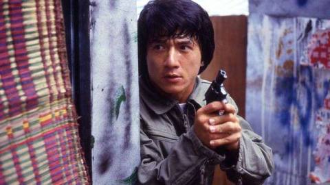 Jackie Chan as police inspector Chan Ka-Kui holds a revolver as he peers around a corner in Police Story