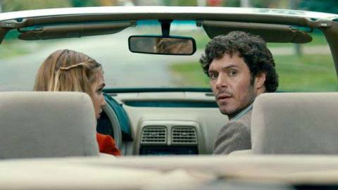 Adam Brody as P.I. Abe Applebaum looks behind himself from the passenger seat of Gracie Gulliver’s (Kaitlyn Chalmers-Rizzato) car in The Kid Detective