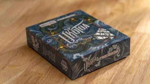 The box art for Uk’Otoa features an intricate seascape, the monster, and a sailing ship caught in its grasp.