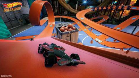 Hot Wheels cars race on an orange race track in a screenshot from Hot Wheels Unleashed