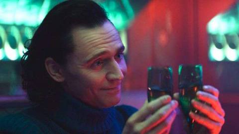 Loki lifting two flutes of champagne in bisexual lightning