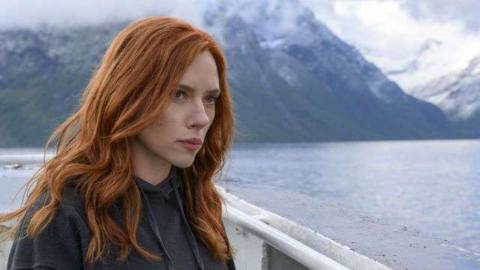 Scarlett Johansson, seen with long red hair standing on a ferryboat in Black Widow