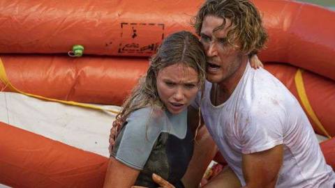 Katrina Bowden and Aaron Jakubenko clutch each other in terror in a lifeboat in Great White