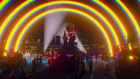 Grand Theft Auto Online - characters on a roleplay server pose under a giant modded rainbow banner at a brightly lit dance party