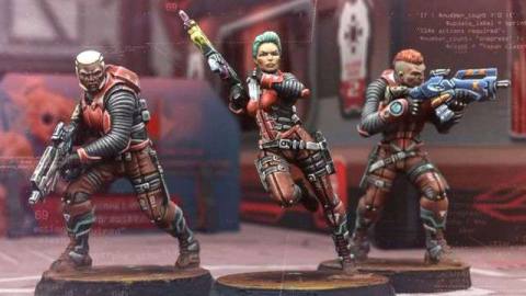 Three Nomad miniatures take aim with assault rifles. They’re dressed in red armor.