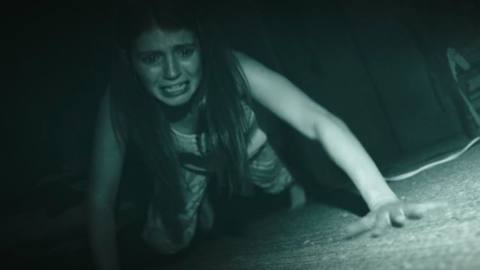 A character crawls around in the dark in Paranormal Activity: Next of Kin