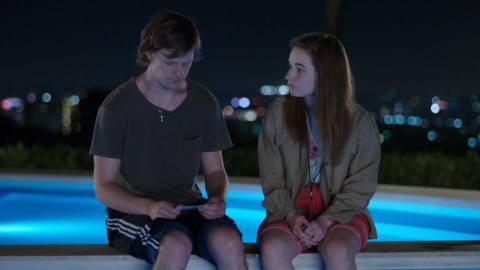 Lucas Hedges and Kaitlyn Dever sit on the edge of the pool in the third episode of FX on Hulu’s The Premise