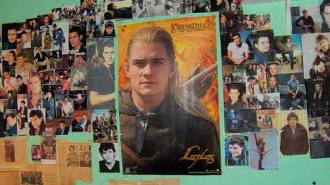 Photo of a bedroom wall featuring images and press clippings of Legolas from The Lord of the Rings movie.