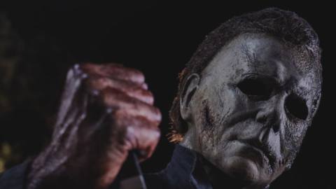 Michael Myers in closeup, brandishing a blood-covered knife, in Halloween Kills