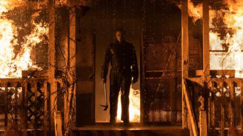 Michael Myers silhouetted against the doorway of a burning house in Halloween Kills
