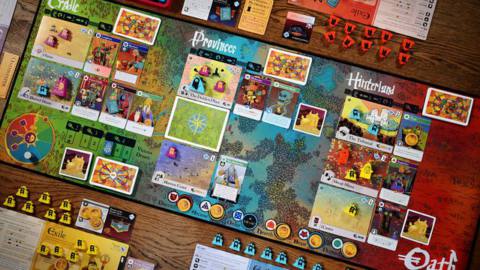 The base game of Oath laid out to play for six. The central game board is made of cloth, like a mousepad.