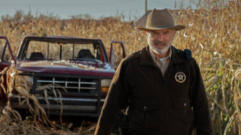 Sam Neill as Sheriff John Bell Tyson stands in a cornfield in the Apple TV Plus show Invasion