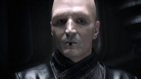 David Dastmalchian as Piter De Vries in Dune. His pale skin is marked with a dark, vertical, and rectangular tattoo on his lower lip. 