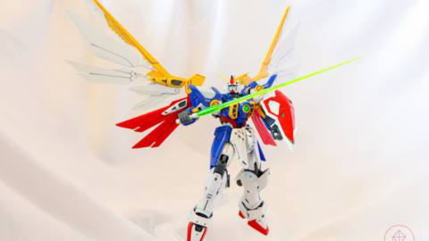 The Wing Gundam Gunpla kit floats in the air, supported by a clear plastic stand.