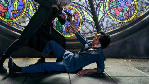 John Cho’s Spike stands with his gun in Vicious’ face in front of stained glass in Cowboy Bebop