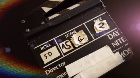 A clapboard hangs open with a light refraction