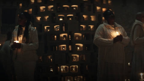 Women in choir robes, holding candles in the dark, sing Radiohead’s “Karma Police” in a sequence from Y: The Last Man.