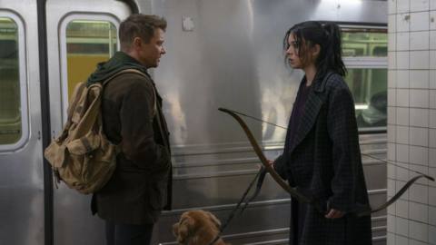 hailee steinfeld and jeremy renner in front of a subway station 
