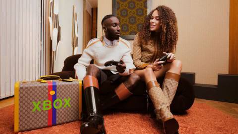 A man and woman play with Xbox controllers for Gucci’s new line