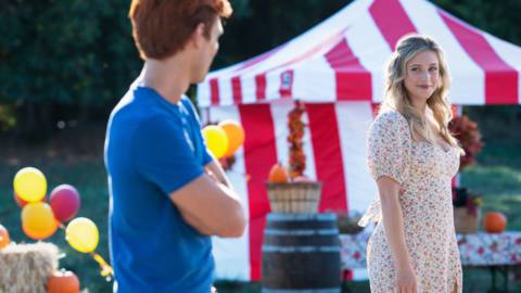 Archie and Betty look at each other at a carnival during the season 6 premiere of Riverdale