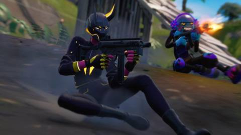 Two Fortnite characters slide down an incline while firing their weapons
