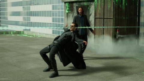 Keanu Reeves walking behind Neo dodging bullets in The Matrix Awakens