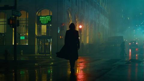 a silhouetted Neo walks toward a coffee shop called Simulatte in The Matrix Resurrections