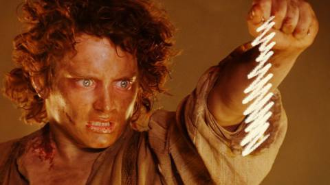 Frodo holds up the One Ring on a chain that has been scribbled out