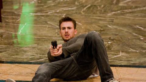 Chris Evans on his back holding a gun in Push